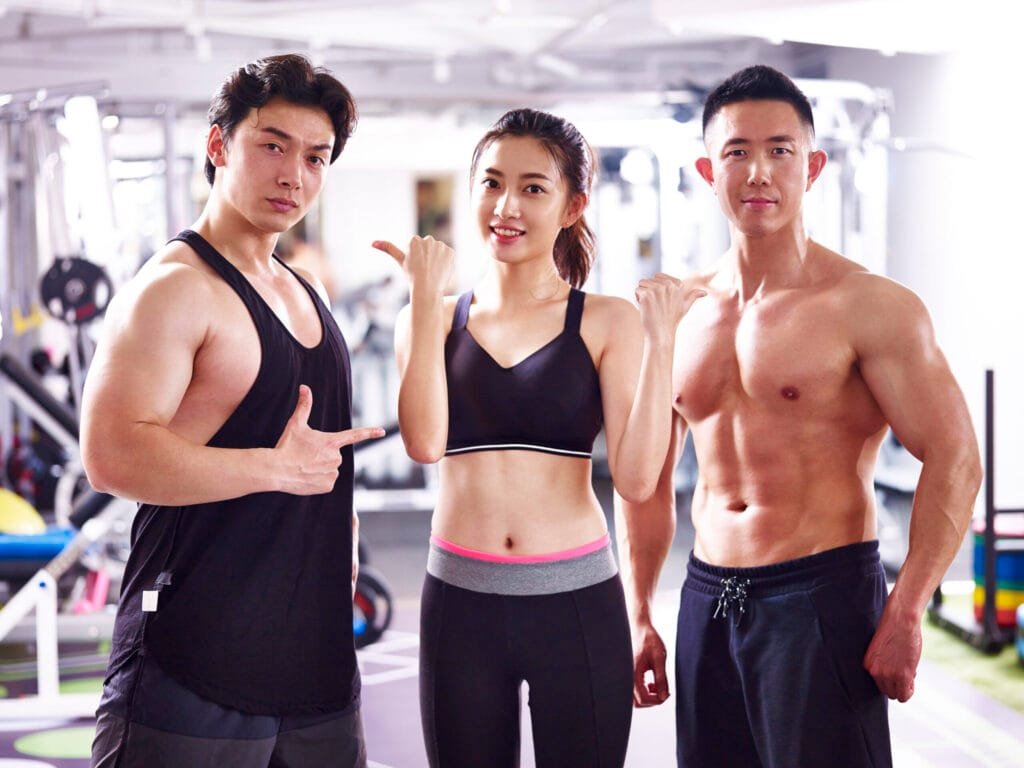 Client posing with trainers in the gym